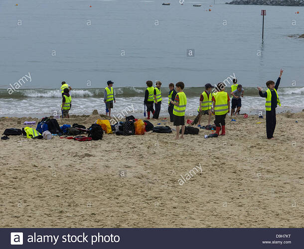 -playing-on-beach-wearing-hi-vis-jackets-D9H7KT.jpg